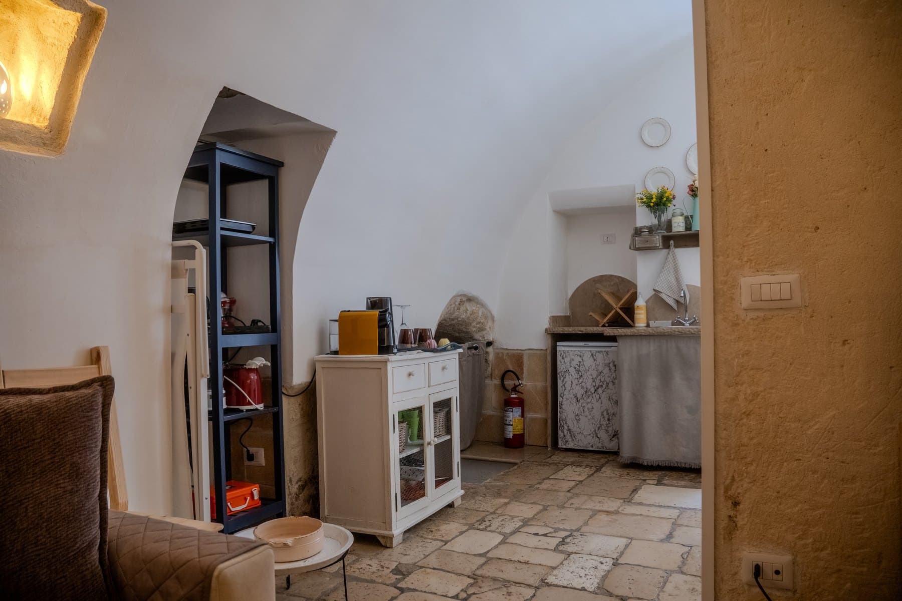 L’angolo con la macchina del caffè, la credenza e il passaggio ad arco verso la cucina